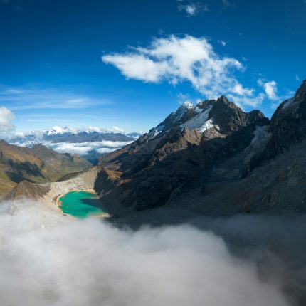 Turquoise Humantay Lake surrounded by snow-capped mountains under a blue sky on the Salkantay trek.